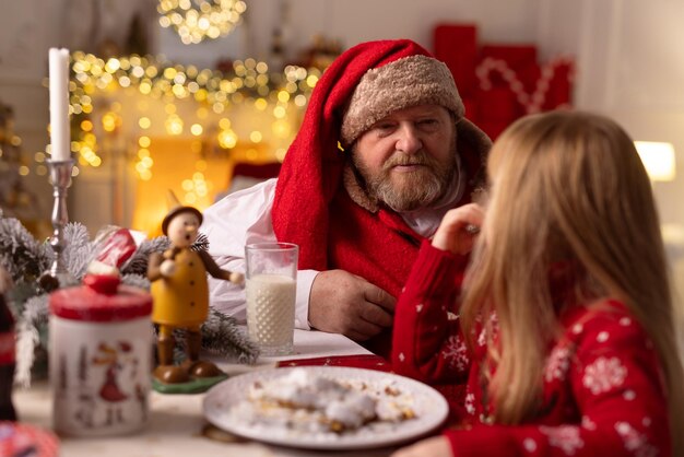 Cheerful santa sits in the house at the table christmas concept