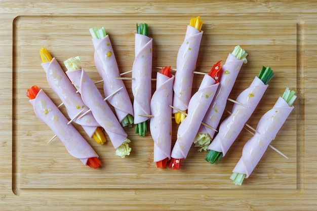 Cheerful sausage rolls with raw vegetables Snack