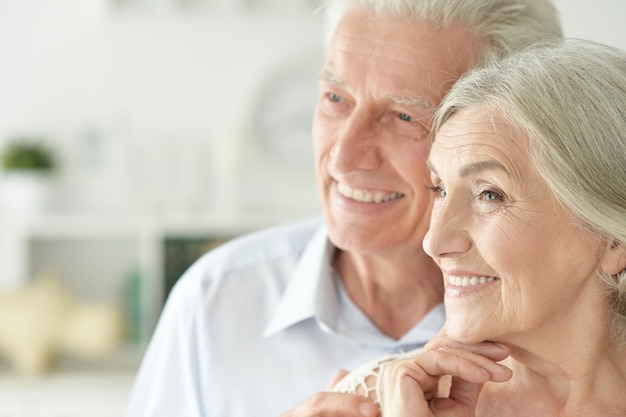 Cheerful senior couple embracing at home