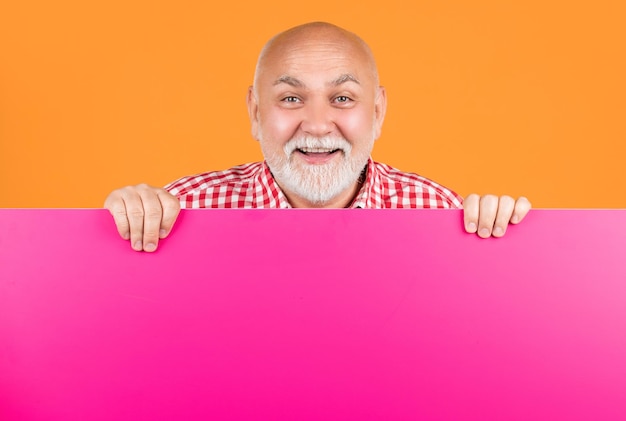 Cheerful senior man with copy space on blank banner advertising