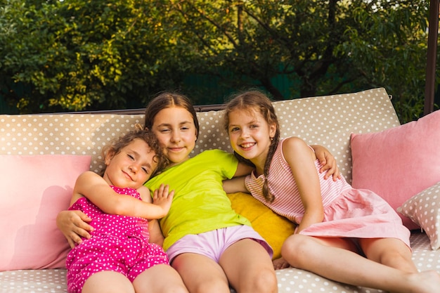 Cheerful sister laying on porch swing embracing