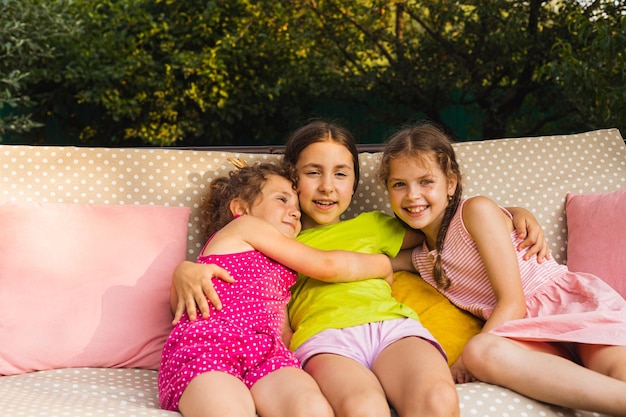 Cheerful sister laying on porch swing embracing