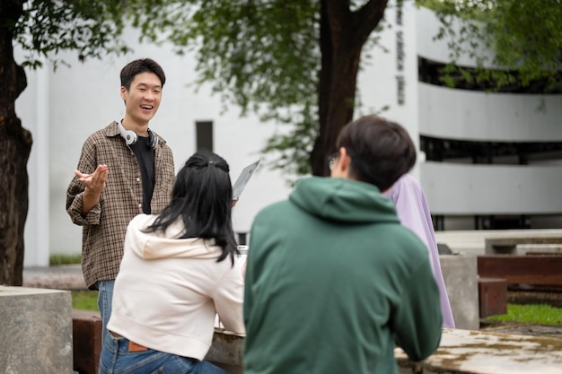 A cheerful and smart Asian male college student is tutoring math to hisa friends in a campus park