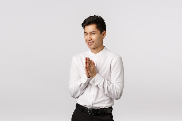 Cheerful smiling asian young entrepreneur with white shirt praying