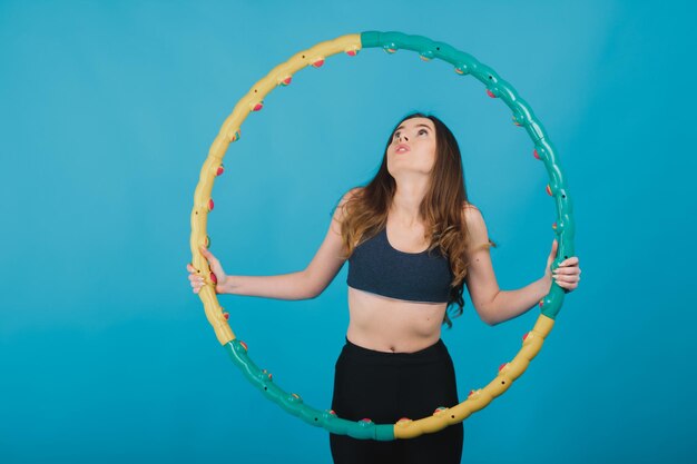 cheerful sport girl with hula hoop on blue background