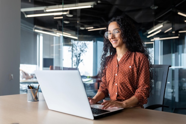 Cheerful and successful indian woman programmer at work inside modern office tech support worker