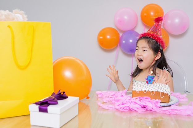 Cheerful surprised little girl at her birthday party