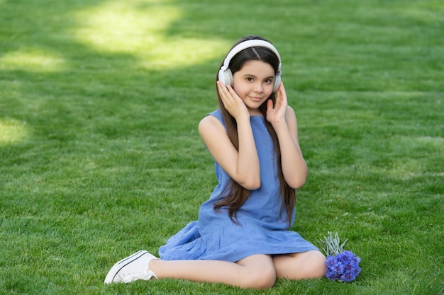 Cheerful teen girl listen music child in wireless music headphones kid listening to music