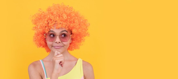 Cheerful thinking teen girl in sunglasses on yellow background emotions Funny teenager child party