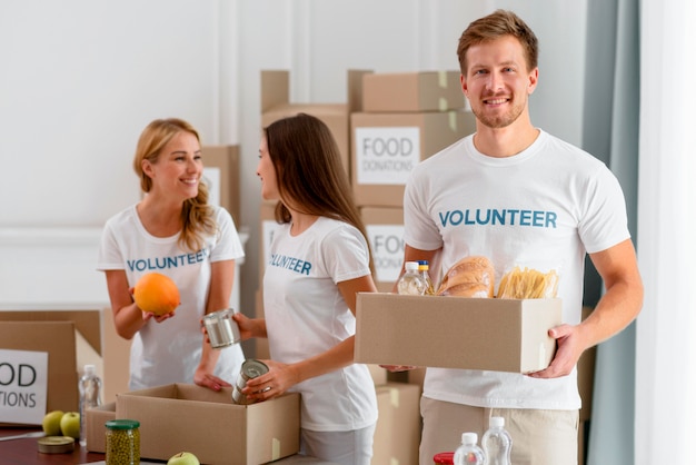 Cheerful volunteers helping with provisions for charity