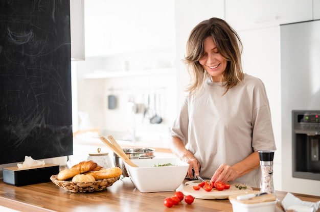 Cheerful woman cooking on modern kitchen