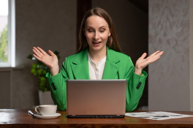 Cheerful woman gets happy looking at screen of laptop