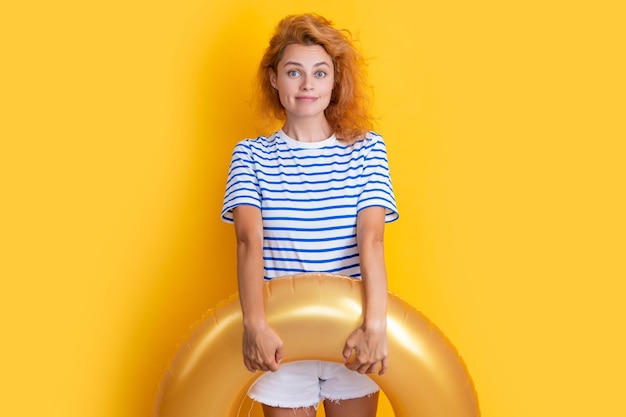 Cheerful woman with inflatable ring isolated on yellow background summer vacation