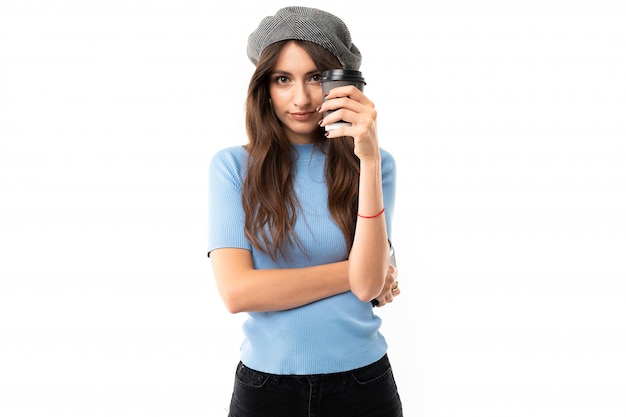 Cheerful woman with long hair drinks coffee isolated on white