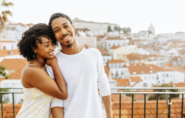 Cheerful young african american woman hugging man in city enjoy date and travel outdoor