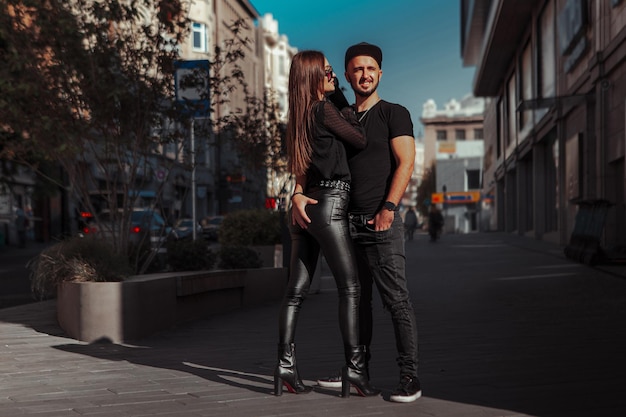 Cheerful young couple hugs in the street daytime