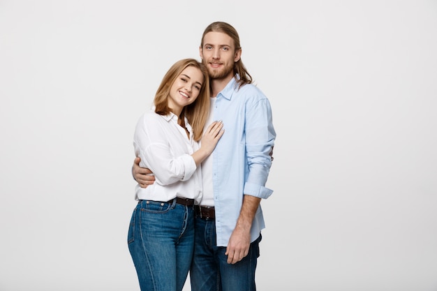 Cheerful young couple standing and hugging each other