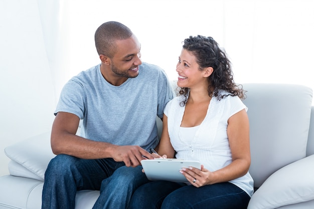 Cheerful young couple with clipboard