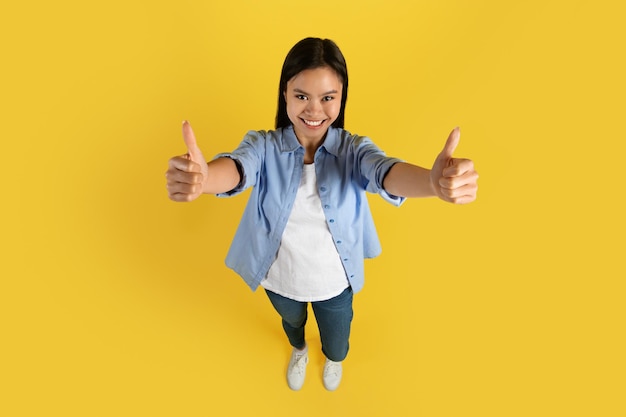 Cheerful young japanese lady student in casual showing thumbs up recommended sale