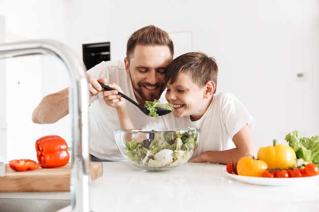 Cheerful young man father dad cooking with his son