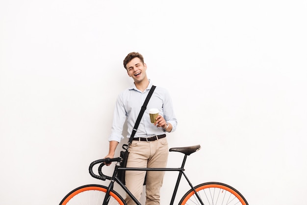 Cheerful young stylish man dressed in shirt carrying bag