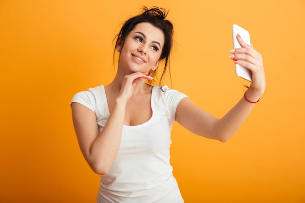 Cheerful young woman make selfie by mobile phone.