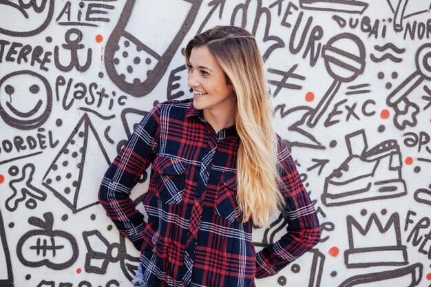 Photo cheerfull teenager in a graffiti wall.