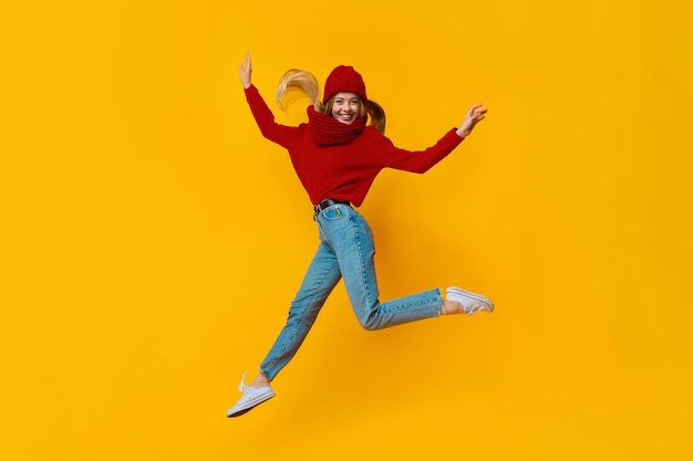 Cheery blonde girl having fun over yellow background