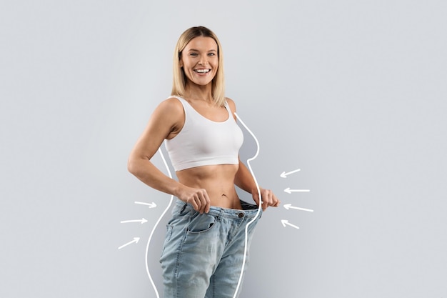 Cheery slender blonde woman wearing huge jeans