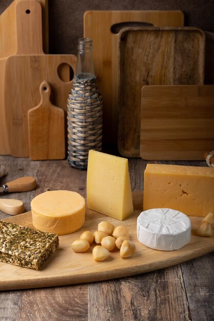 Cheese assorted on a wooden board rustic style Several varieties of whole cheese parmesan tilsiter halloumi with spices camembert smoked bocconcini cheddar Selective focus closeup