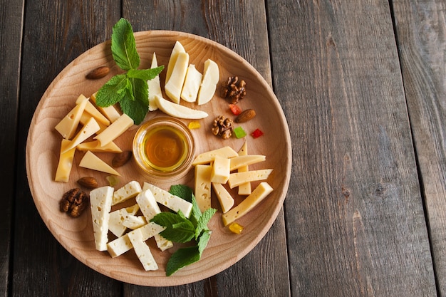 Cheese assortment plate on dark wooden