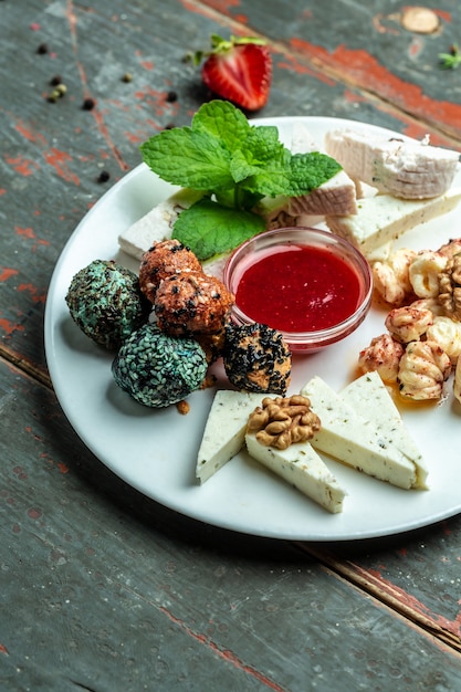 Cheese Assortment plate served with with jam, nuts. craft sheep goat cheese