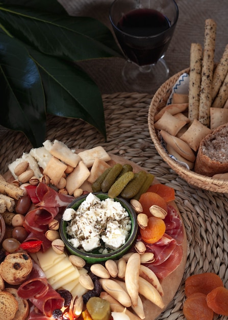 Cheese board with appetizer selection, cheese variety, cured meat, crackers, olives. Colorful meal. Top view.