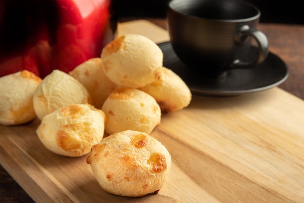 Cheese bread Basket with cheese bread lying on rustic wood red kettle and accessories dark background selective focus