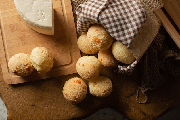 Cheese bread, Brazilian breakfast arrangement, cheese bread, white cheese, kettle and accessories, dark abstract background, top view.