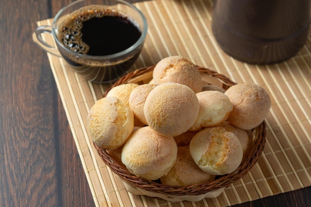 Cheese breads in wooden basket with cup of coffee. pão de queijo