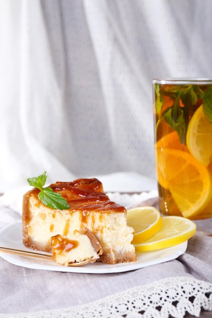 Cheese cake in plate and herbal tea on napkin on curtain background