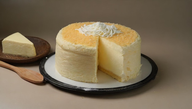 a cheese cake with a piece of coconut on it next to a piece of cake