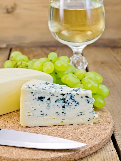 Cheese different with grapes and wine on the board