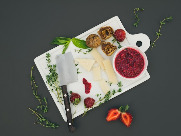 Cheese and fruit set on a dark surface