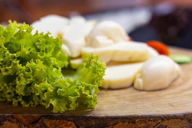 Cheese and lettuce on wooden plate