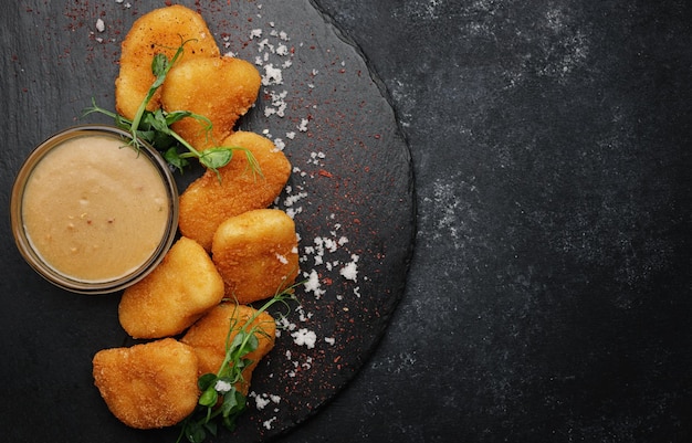 Cheese nuggets with sauce on black stone