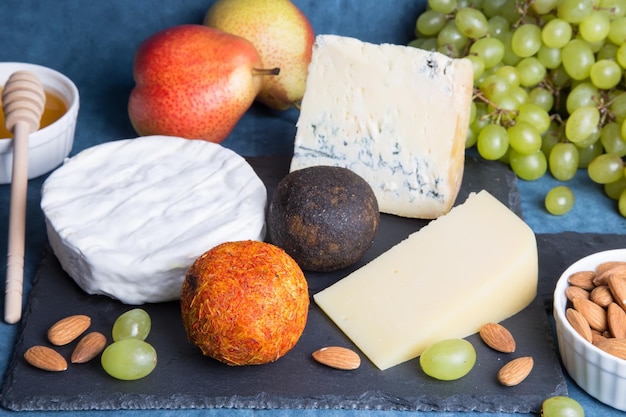 Cheese plate 5 species of cheese fruit nuts Closeup selective focus