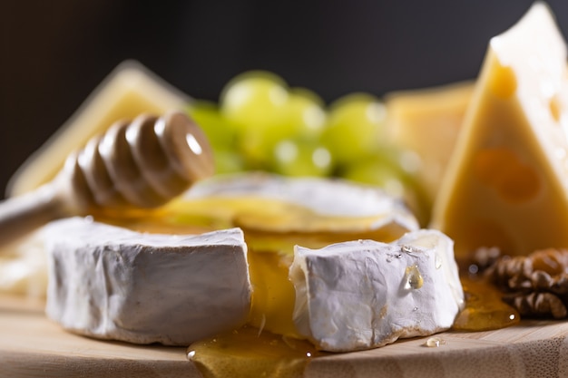 Cheese plate, honey pouring on camembert cheese