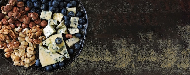 Photo cheese plate with blue cheese, nuts and blueberries. healthy snack. keto diet