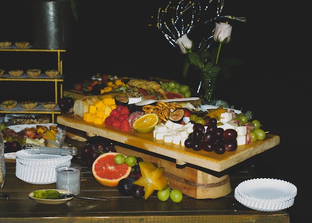 Cheese platter with fruits and cold meats during an evening celebration