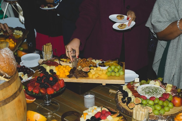 Cheese platter with fruits and cold meats during an evening celebration