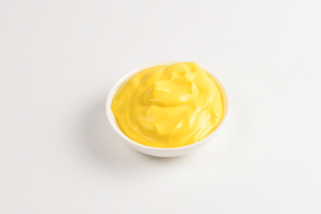 Cheese sauce in white plate on white background.