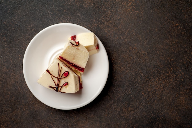 Cheesecake - cake on a white plate on a stone background with copy space for your text