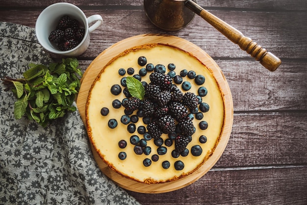 Cheesecake with blackberries almond strawberries on the concrete background with napkin